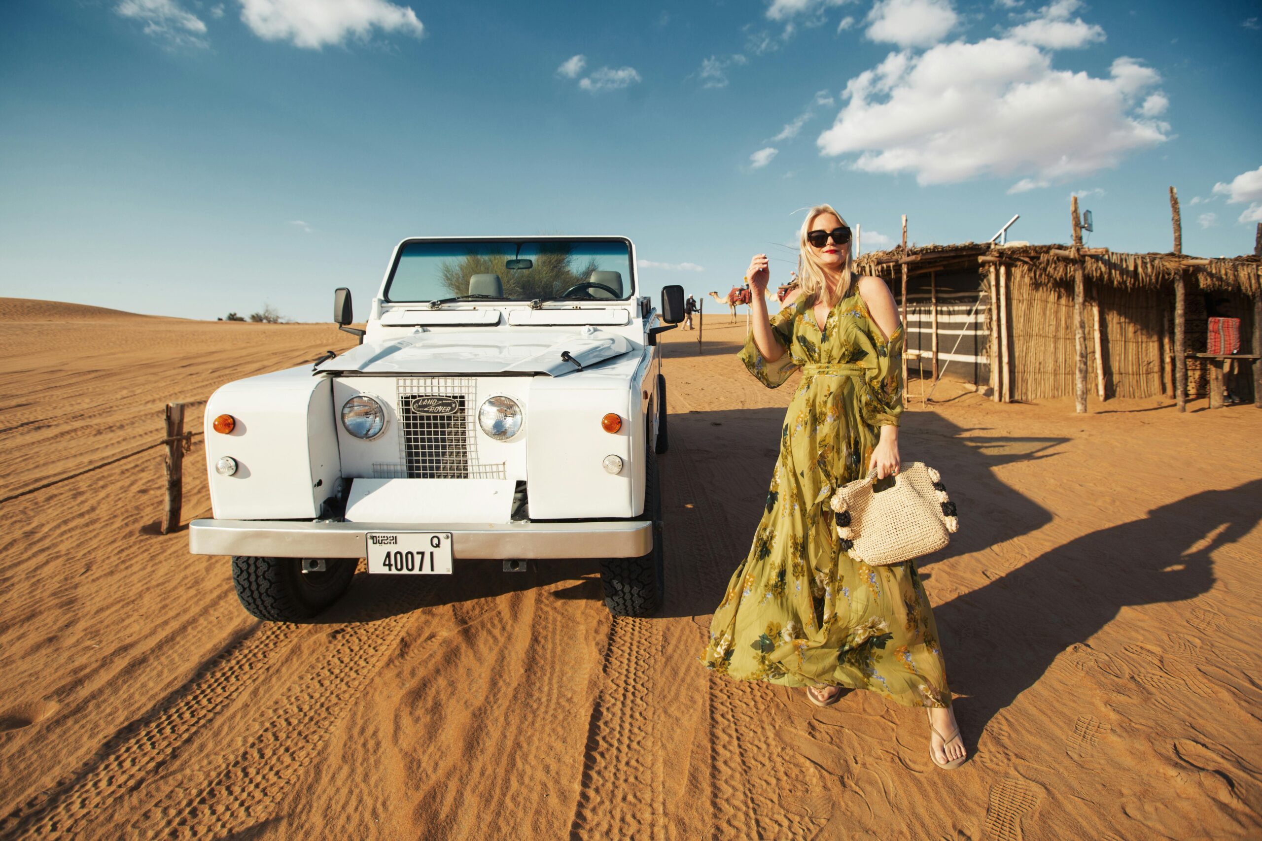 A Woman in a Dress Standing beside a White Car